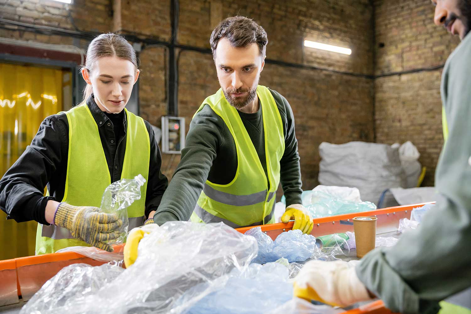 male-worker-in-protective-vest-taking-plastic-from-NXQ5HDM.jpg